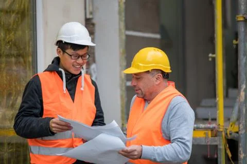 Asian trainee engineer at work on construction site with the senior manager Stock Photos