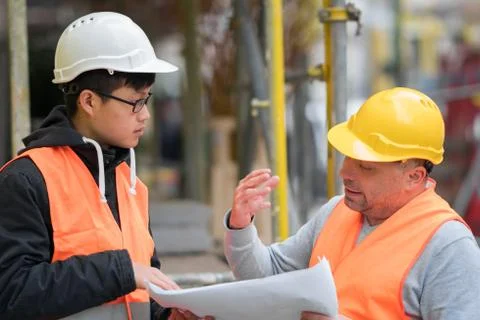 Asian trainee engineer at work on construction site with the senior manager Stock Photos