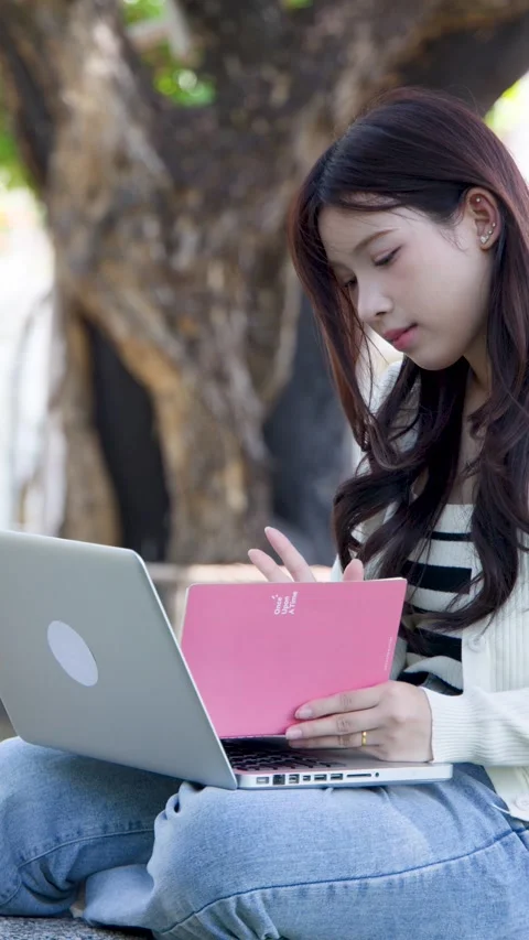 Asian University Student Using Laptop and Notebook in Campus Park Stock Footage 333291570