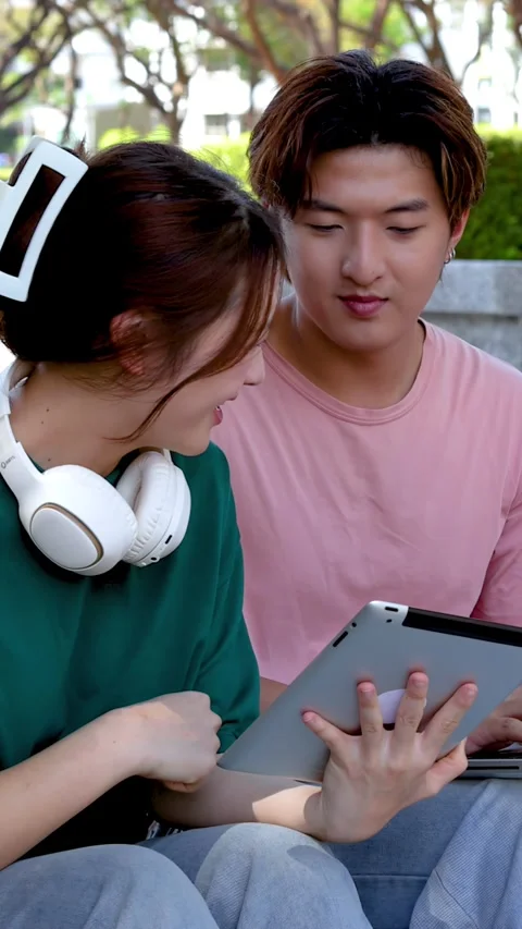 Asian University Students Collaborating on a Digital Tablet Outdoors Stock Footage 332038383