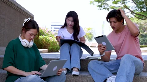 Asian University Students Studying Together with Digital Devices on Campus Steps Stock Footage 328498317