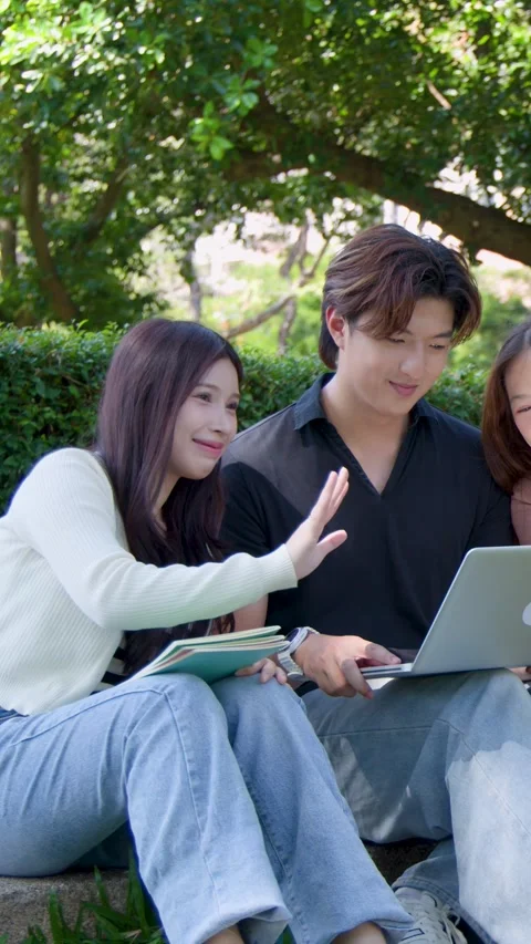 Asian University Students Using Laptop and Waving During Video Call Outdoors Stock Footage 335500482