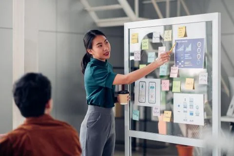 Asian ux developer and ui designer presenting mobile app interface design on  Stock Photos
