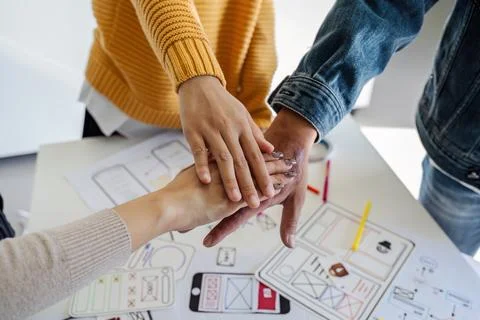 Asian ux developer and ui designer team stacking hands together, celebrating Foto stock
