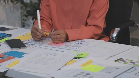 Asian uxui designer working on website design using sticky notes and wirefram Stock Footage 332275575