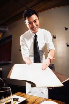 Asian waiter pointing to menu Stock Photos