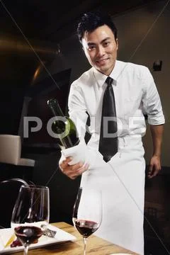 Asian waiter pouring wine Stock Photos