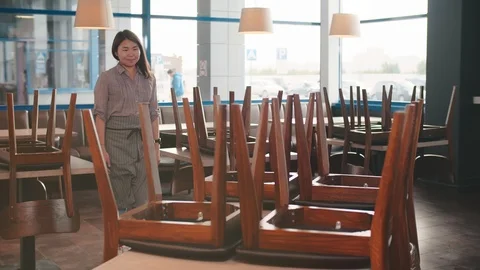 Asian waitress preparing restaurant for opening in morning. Stock Footage 123472901