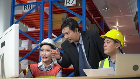 Asian warehouse manager talking to worker with computer and laptop in large w Stock Footage 139570578