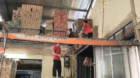 Asian warehouse workers manually loading cardboard boxes Stock Footage 340939146