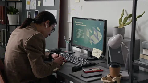 Asian Web Engineer Writing in Notebook While Studying Cybersecurity Stock Footage 336711890