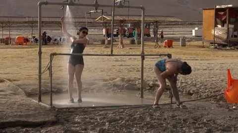 Asian weman put mud and shower at dead sea nature spa Stock Footage 19887915