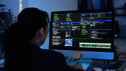 Asian Woman Analyzing Cybersecurity Code on Computer Stock Footage 347285884