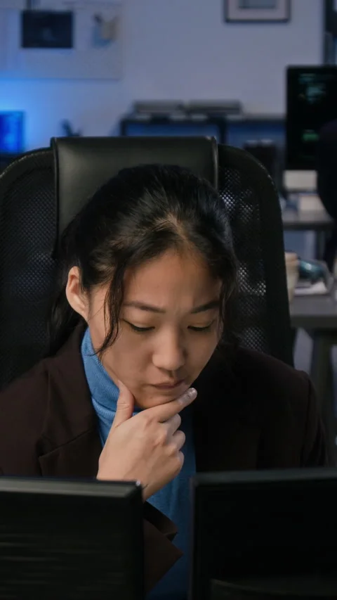 Asian Woman Analyzing Cybersecurity Data on Dual Monitors Stock Footage 347314902