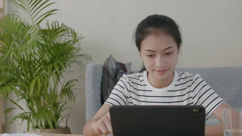 Asian woman are using computer laptop on a desk in the living room at home Stock Footage 139600555