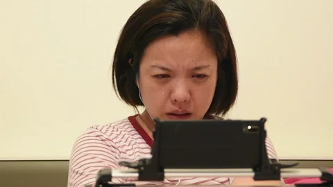 Asian woman crying by watching dramatic series TV in smartphone Video stock 129084101