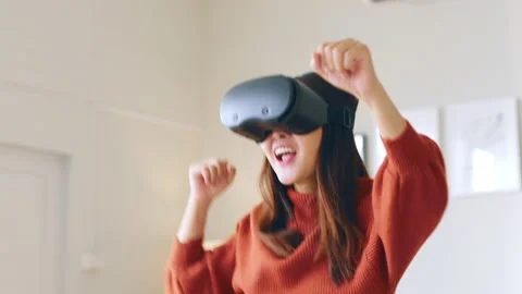 Asian woman dancing while using 360 VR headset for virtual reality, metaverse Stock Footage 189973351