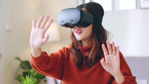 Asian woman excited while using 360 VR headset for virtual reality, metaverse Stock Footage 189974129