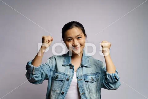 Asian woman happy confident standing showing her fist make a winning gesture Stock Photos
