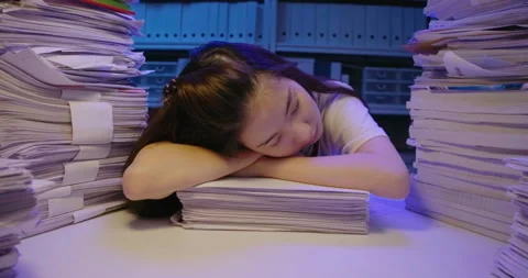 Asian woman lay down on stack of paperwork while studying hard at late night. Video stock 139638756