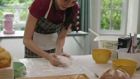 Asian woman making bread, baking in the kitchen at home Stock Footage 160349341