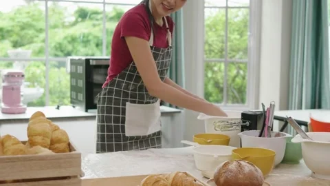Asian woman making bread, baking in the kitchen at home Stock Footage 160349366
