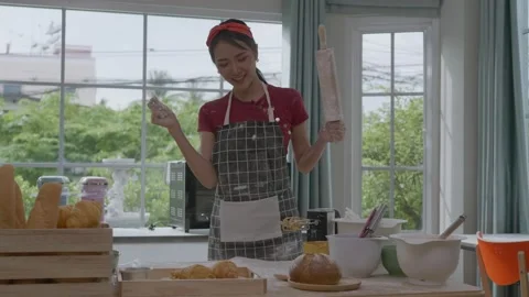 Asian woman making bread, baking in the kitchen at home Stock Footage 160350104