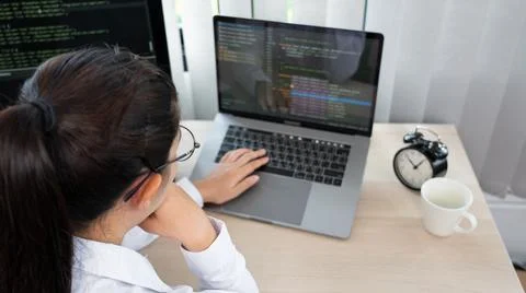 Asian Woman programmer typing source codes Programming On Computer in office, 库存照片