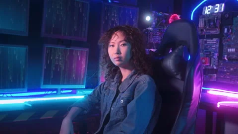 An asian woman programmer is working in her computer room , futuristic tech.. Stockbeeldmateriaal 232945926