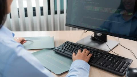 Asian woman Programming working with computer and typing data code to develop Stock Photos