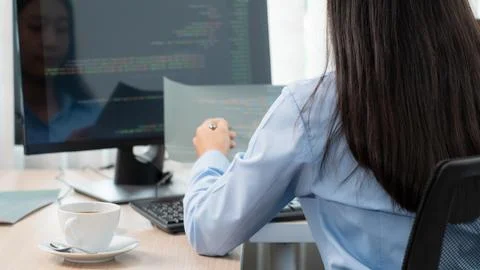 Asian woman Programming working with computer and typing data code to develop 库存照片
