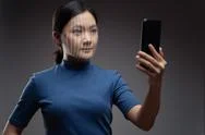 Asian Woman Scans Face By Smart Phone Using Facial Recognition System. Stock Photos