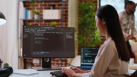 Asian woman is seen typing code for an app development project on her computer Stock Footage 319717411