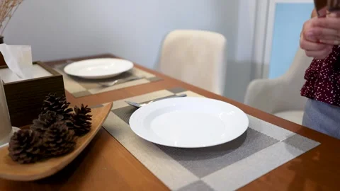 Asian Woman Setting a Dining Table with White Plates and Silverware Stock Footage 335004763