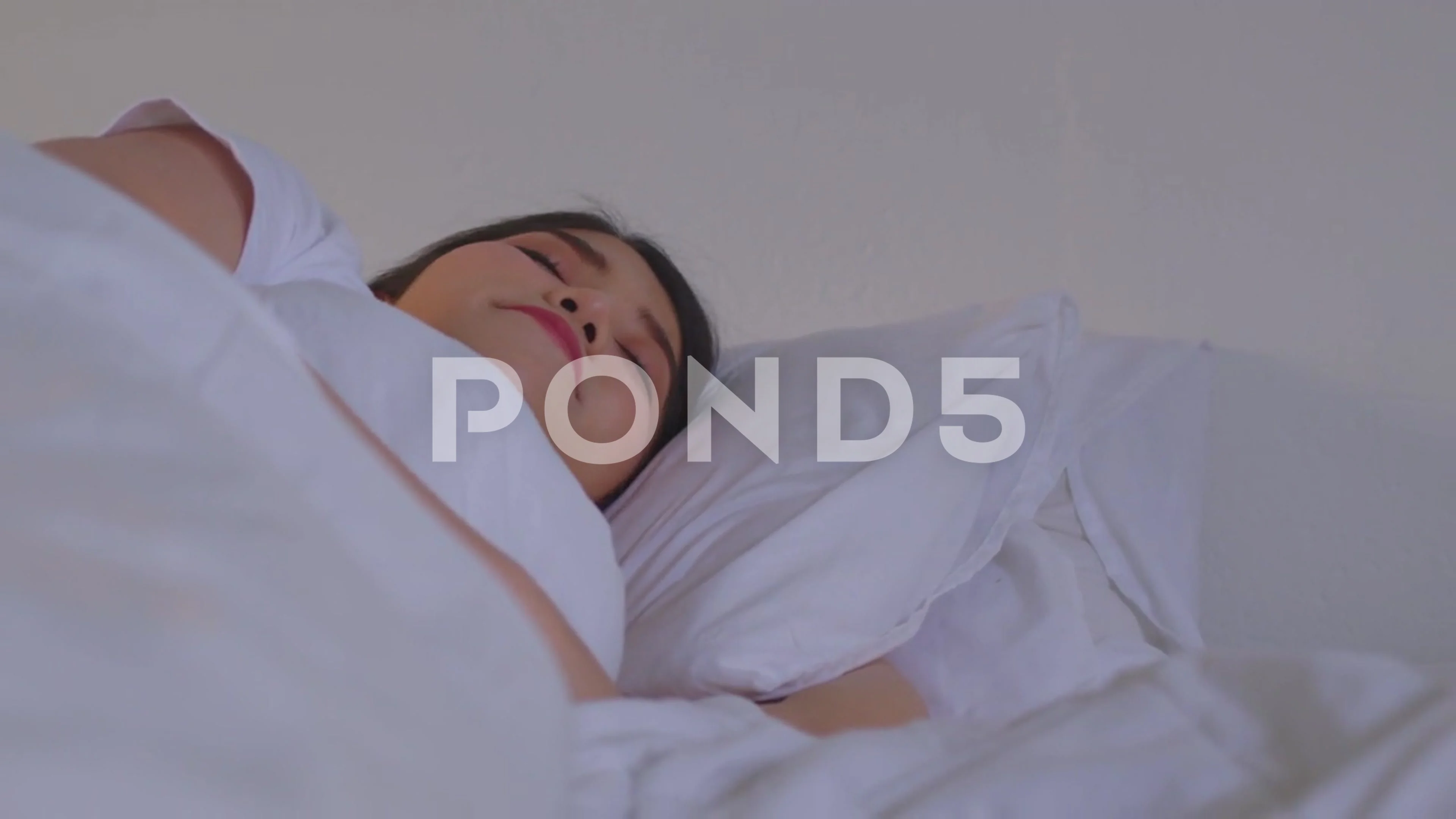 Asian woman sleeping well in a comfy warm fresh bed on a soft pillow white  li