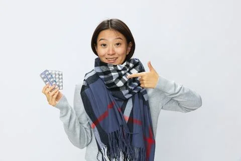 Asian woman smile cold flu holding medicine and pills in plaid with fever sick Stock Photos