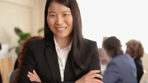 Asian woman smiling on camera while working with colleagues inside bank office Stock Footage 178586201