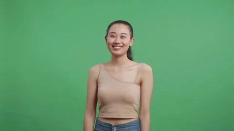 Asian Woman Smiling To Camera While Standing On Green Screen Background Stock Footage 218323648