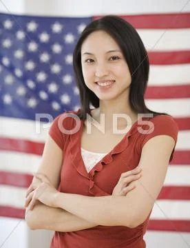 Asian woman standing in front of American flag Stock-Fotos