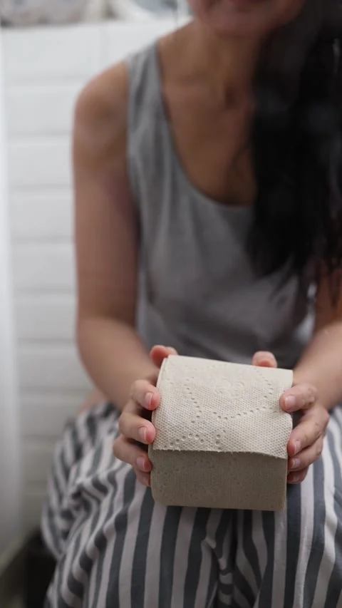 Asian woman struggling with constipation while sitting on the toilet Stock Footage 328034600