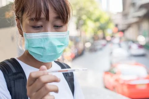 Asian woman with surgical face mask feel tired in front of the road looking a Stock Photos