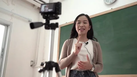 Asian woman teacher teaching and giving online presentation in classroom Stock Footage