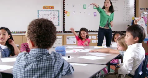 Asian woman teaching young kids in elementary school class Stock Footage