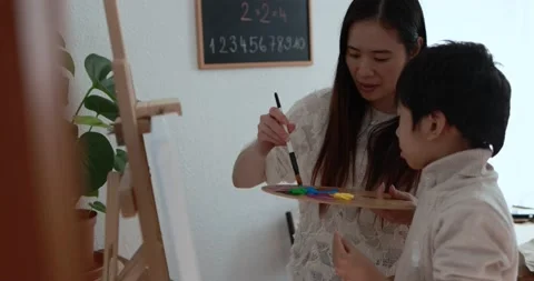 Asian woman using brush for doing color paint with child Stock Footage 149116148