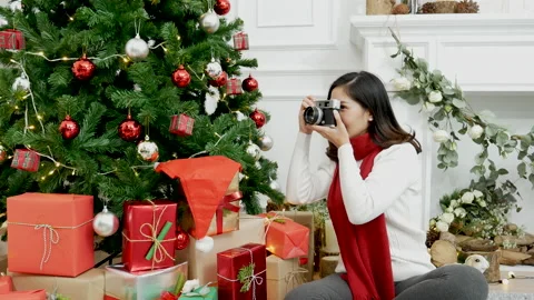 Asian woman using camera take photo christmas tree xmas present gift box in cozy Stock Footage 160243485