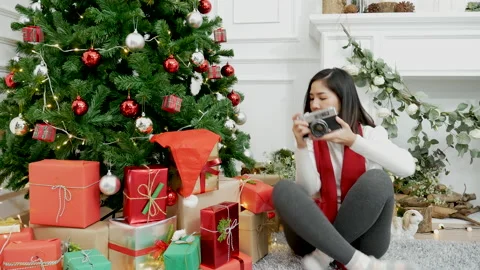 Asian woman using camera take photo christmas tree xmas present gift box in cozy Видео 160243614