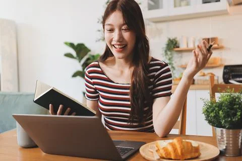 Asian woman using computer remote for business studying, watching online vi.. Stock-Fotos