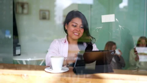 Asian woman using a digital tablet and drinking coffee in a cafe Stock Footage 336717692