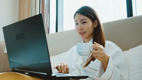 Asian woman using a laptop while have a morning coffee in hotel room Stock Footage 160567993