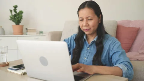 Asian woman using laptop while sitting workplace at home. Stock Footage 231488896